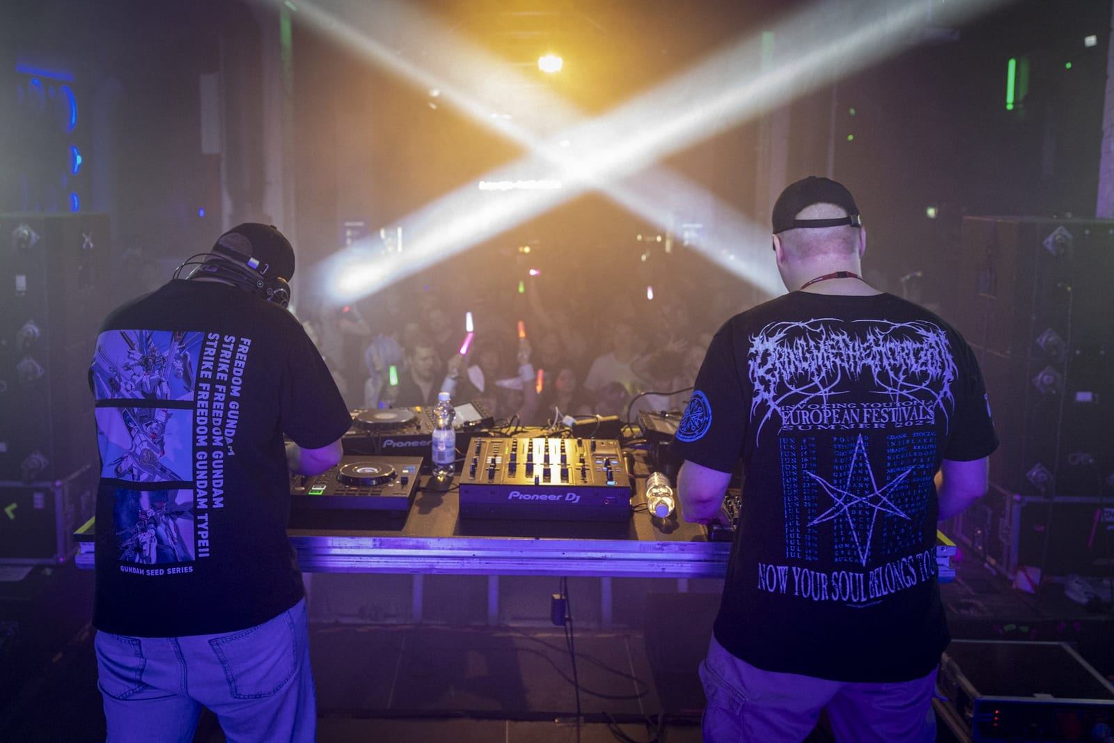 Nemurai at the decks seen from behind, light beams crossing over the crowd
